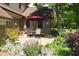 Cozy backyard patio with brick exterior, a red umbrella, and outdoor seating for relaxing at 1065 Lakewood South Dr, Brownsburg, IN 46112