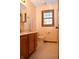 Bright bathroom featuring a vanity with drawers, a toilet, and a window with blinds for natural light at 1065 Lakewood South Dr, Brownsburg, IN 46112