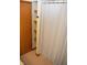 Neutral bathroom featuring a linen shower curtain, built in shelving, and a light pink tile floor at 1065 Lakewood South Dr, Brownsburg, IN 46112