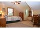 Bright bedroom with a sloped ceiling, ceiling fan, neutral carpet, and furnishings at 1065 Lakewood South Dr, Brownsburg, IN 46112