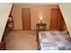Large carpeted bedroom with two closets, neutral decor, warm lighting, and vintage-style wooden furniture at 1065 Lakewood South Dr, Brownsburg, IN 46112