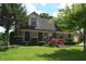 Well-maintained home with lush lawn, mature trees, brick facade, attached garage and red Japanese maple at 1065 Lakewood South Dr, Brownsburg, IN 46112