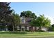Traditional brick home with dormer windows and a well-manicured lawn with mature trees at 1065 Lakewood South Dr, Brownsburg, IN 46112
