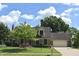 Well-maintained two-story home with lush lawn, mature trees, brick facade, attached garage and basketball hoop at 1065 Lakewood South Dr, Brownsburg, IN 46112