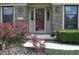 Charming brick home entrance with a red front door, complemented by a Japanese maple and professional landscaping at 1065 Lakewood South Dr, Brownsburg, IN 46112