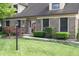Charming home with a lush green lawn, mature landscaping, brick facade, trimmed hedges and pathway to the front door at 1065 Lakewood South Dr, Brownsburg, IN 46112