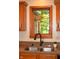 Close up of a double basin sink in a kitchen with wood trim and a view of the backyard at 1065 Lakewood South Dr, Brownsburg, IN 46112