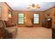 Bright living room with carpeted floors, a ceiling fan and natural lighting through the windows at 1065 Lakewood South Dr, Brownsburg, IN 46112