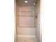 Modern tiled shower equipped with built-in bench and convenient recessed shelving for toiletries at 1065 Lakewood South Dr, Brownsburg, IN 46112