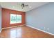Bright bedroom features a ceiling fan, large window, and warm hardwood floors at 10725 Tedder Lake Dr, Indianapolis, IN 46239