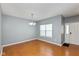 Bright living room boasts wood floors, neutral walls, modern light fixture, and ample natural light at 10725 Tedder Lake Dr, Indianapolis, IN 46239