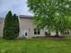 The backyard features a patio door entrance, windows, and a lush lawn, framed by a mature shade tree at 11070 Long Lake Ln, Fishers, IN 46037