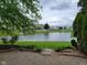 A picturesque backyard offers a serene pond view, complemented by lush greenery and a paver patio at 11070 Long Lake Ln, Fishers, IN 46037