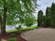 A tranquil backyard features a scenic pond view, enhanced by mature trees and a brick-edged paver patio at 11070 Long Lake Ln, Fishers, IN 46037