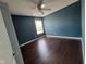 Bedroom with hardwood floors, ceiling fan, and blue accent wall at 11070 Long Lake Ln, Fishers, IN 46037