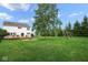 Spacious backyard with mature tree, fire pit, and swing set at 11198 N 650 W, Fountaintown, IN 46130
