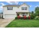 Two-story home with a manicured lawn, beautiful landscaping, and an attached two-car garage at 11198 N 650 W, Fountaintown, IN 46130