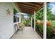 Covered front porch features outdoor seating and views of the beautifully landscaped yard at 11198 N 650 W, Fountaintown, IN 46130