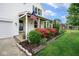 Charming front porch with an American flag, lush greenery, and a cozy seating area at 11198 N 650 W, Fountaintown, IN 46130