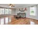 Sunlit living room featuring hardwood floors, a ceiling fan, and three large windows at 11198 N 650 W, Fountaintown, IN 46130