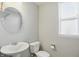 Bathroom featuring a pedestal sink, toilet, and window, providing natural light and essential amenities at 1221 Hamilton Dr, Greenwood, IN 46143
