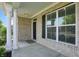 Inviting front porch showcasing brick siding, white columns, and a charming entrance at 1221 Hamilton Dr, Greenwood, IN 46143