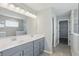Main bathroom featuring double sink vanity with quartz counters, framed mirrors, modern lighting and large tile shower at 1221 Hamilton Dr, Greenwood, IN 46143