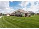 Spacious backyard featuring a well-manicured lawn, brick exterior, and patio area with outdoor seating at 1227 Highbury Dr, Danville, IN 46122