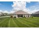 Expansive backyard with lush green lawn, a charming brick house, and a cozy patio area for relaxation at 1227 Highbury Dr, Danville, IN 46122