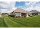 Picturesque backyard with a well-maintained lawn, brick house, and a peaceful patio space for outdoor enjoyment at 1227 Highbury Dr, Danville, IN 46122