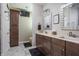 This bathroom features double sinks, wood cabinets, and a TV mounted on the wall at 1227 Highbury Dr, Danville, IN 46122