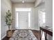 Inviting entryway with hardwood floors, a decorative rug, and a view of the bright, welcoming front door at 1227 Highbury Dr, Danville, IN 46122