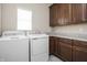 Bright laundry room featuring modern appliances, countertops and ample dark wood cabinet storage at 1227 Highbury Dr, Danville, IN 46122