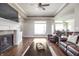 Cozy living room featuring a fireplace, hardwood floors, and comfortable leather seating at 1227 Highbury Dr, Danville, IN 46122