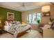Bright bedroom with a large window, ceiling fan, vibrant bedding, and a sitting area at 131 Olde Mill Bay, Indianapolis, IN 46260
