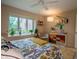 Well-lit bedroom boasts a window view, vibrant dresser, ceiling fan, and comfortable seating at 131 Olde Mill Bay, Indianapolis, IN 46260