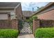 Charming brick home featuring a decorative iron gate and lush green landscaping at 131 Olde Mill Bay, Indianapolis, IN 46260