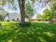 Lush backyard with brick-lined garden beds, mature trees and grassy lawn at 1325 Countryside Ln, Indianapolis, IN 46231