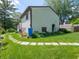 Well-maintained backyard with a stone pathway, leading through green grass and gardens along the side of the home at 1325 Countryside Ln, Indianapolis, IN 46231
