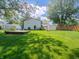 Lush green backyard with large grassy area, utility sheds and garden at 1325 Countryside Ln, Indianapolis, IN 46231