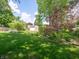 View of the lush, green backyard with a shed and mature trees, providing a serene outdoor space at 1325 Countryside Ln, Indianapolis, IN 46231