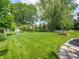 Backyard with lush lawn, mature trees and shrubs, and tidy garden beds at 1325 Countryside Ln, Indianapolis, IN 46231