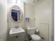 Powder room with a pedestal sink, toilet, and decorative mirror at 1325 Countryside Ln, Indianapolis, IN 46231