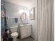 Bathroom with white vanity, toilet, fixtures, white woven mirror and white shower curtain at 1325 Countryside Ln, Indianapolis, IN 46231