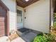 Exterior shot of front entrance of the house featuring a screen door and beige vinyl siding at 1325 Countryside Ln, Indianapolis, IN 46231