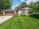 Beautiful house with a well manicured front lawn with professional landscaping surrounding the perimeter at 1325 Countryside Ln, Indianapolis, IN 46231