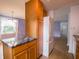 Kitchen island with stone countertop and cabinets next to white refrigerator at 1325 Countryside Ln, Indianapolis, IN 46231