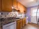 Well-lit kitchen featuring wooden cabinets, granite countertops, and modern white appliances at 1325 Countryside Ln, Indianapolis, IN 46231