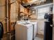 Small laundry room features washing machine and dryer with shelving and window at 1325 Countryside Ln, Indianapolis, IN 46231