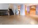 Open-concept living room with staircase, hardwood floors, and access to eat-in kitchen at 1325 Countryside Ln, Indianapolis, IN 46231